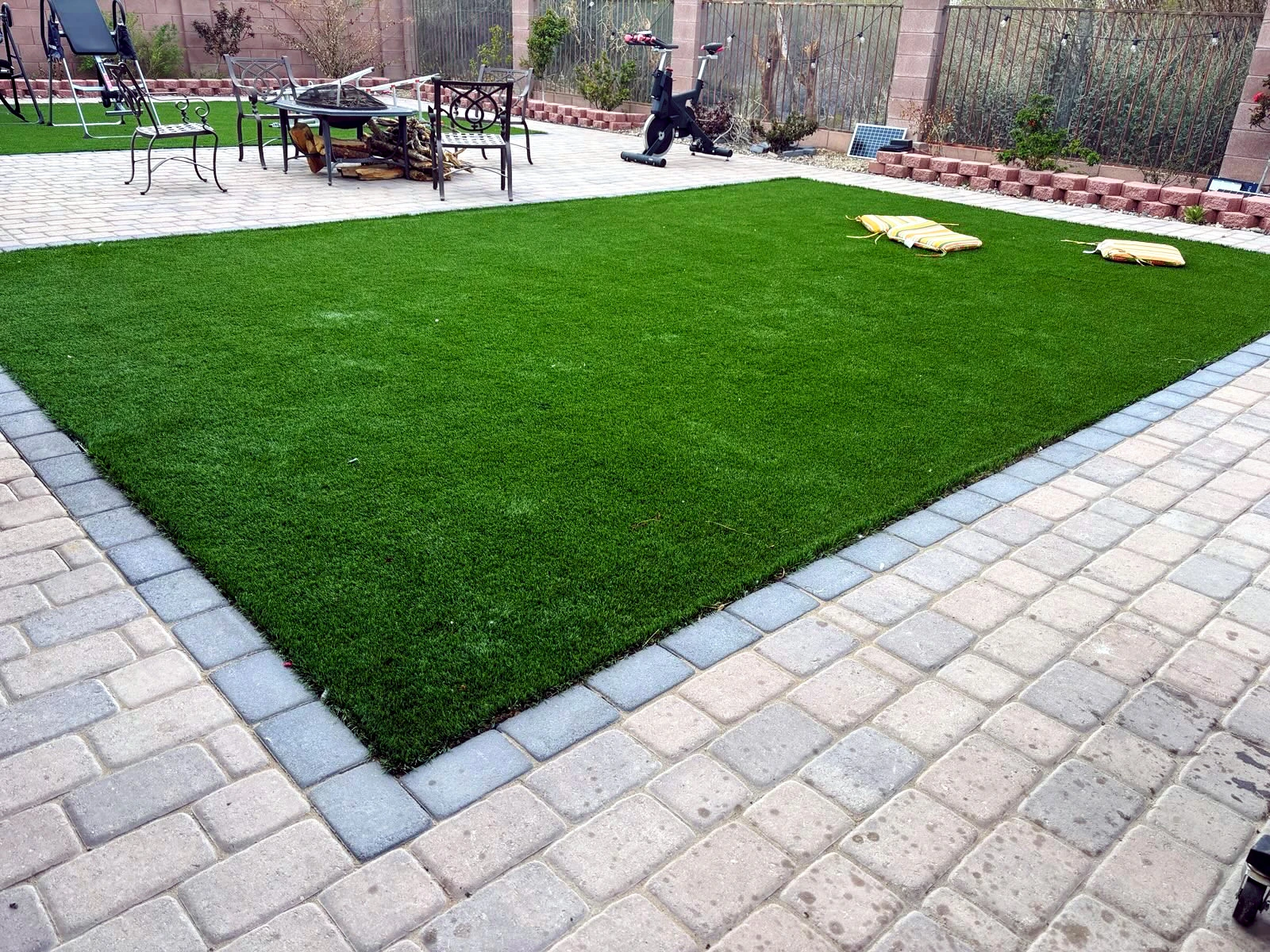 A grass patio with tiling around the grass